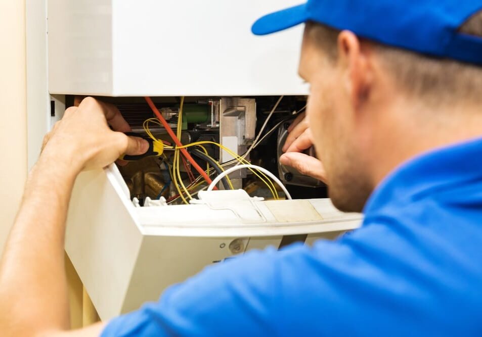 Professional Hot Shot Electric certified electrician repairing breaker box with screwdriver – licensed Tulsa experts fix tripped breakers and upgrade panels for safe, reliable home power in Oklahoma.