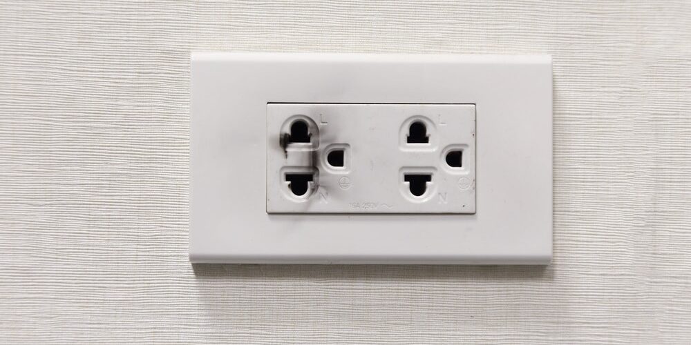 Damaged burnt electrical outlet showing scorch marks – professional Hot Shot Electric licensed experts repair and replace unsafe receptacles for fire safety in Tulsa homes.
